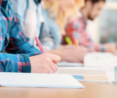 Exams.,Cropped,View,Of,Students,Writing,A,Test,In,Their