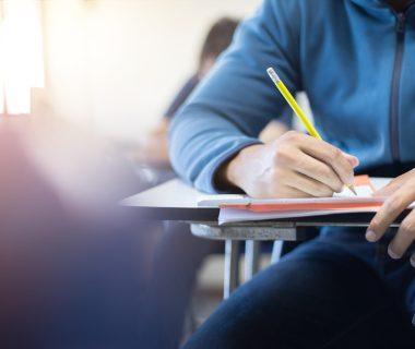 Soft,Focus.high,School,Or,University,Student,Holding,Pencil,Writing,On